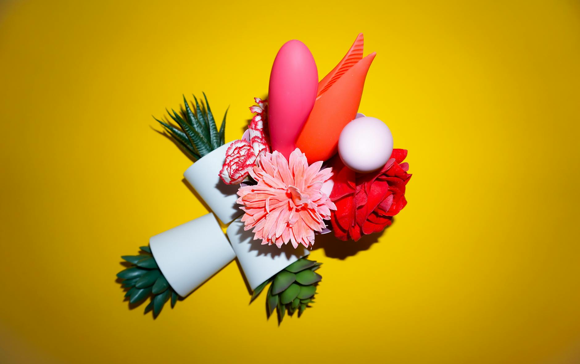 Yellow lemon vibrator surrounded by fresh fruit on a bright background, symbolizing natural pleasure and wellness
